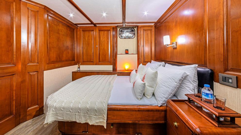 Yelkenli guletin beyaz çarşaflı düzenli yatak odası konforlu konaklama için ayrılmış.