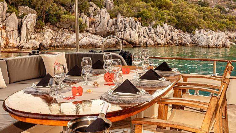 Yelkenli guletin deniz manzaralı güvertesi misafirlere keyifli yemek yeme imkanı sunuyor.